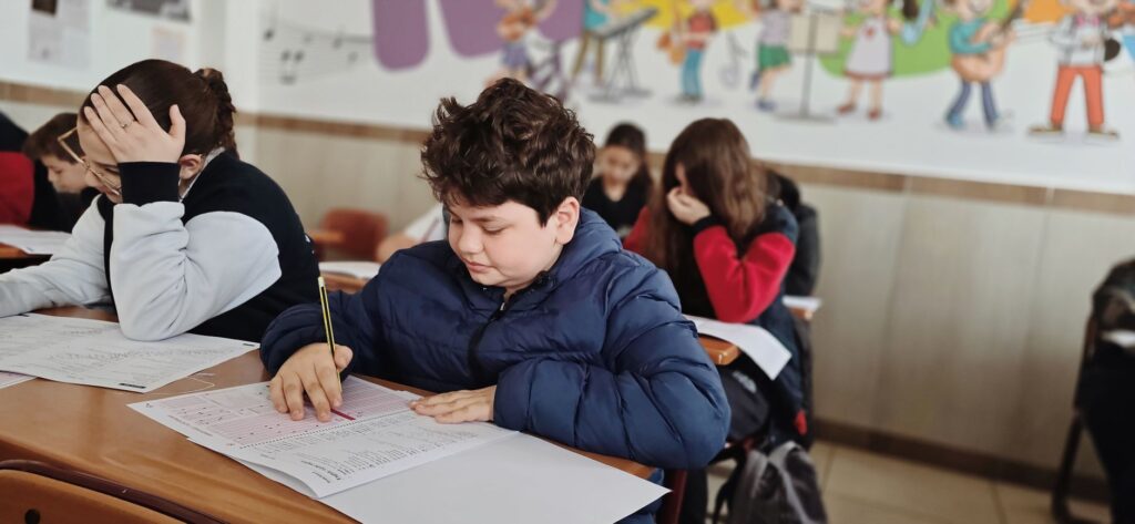 Dzieci skupione na pisaniu testu w klasie szkolnej