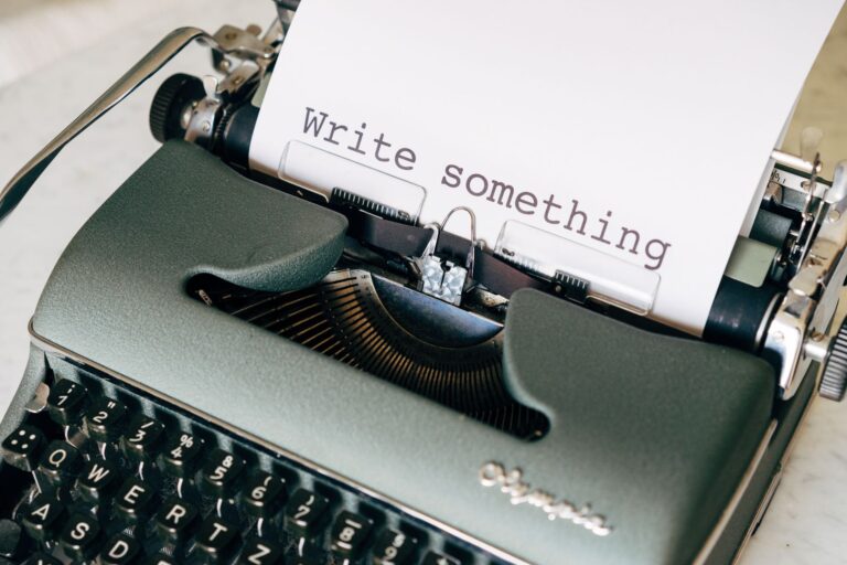 Zabytkowa maszyna do pisania z tekstem „Write something” na papierze